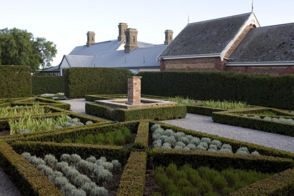 Organized vegetable garden surrounded by boxwoods. Designed by Paul Bangay.