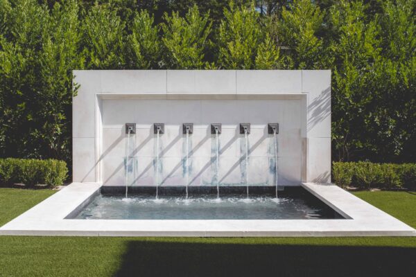 This beautiful carved limestone fountain doubles as a heated spa. The unique Zinc-coated copper water spouts were designed and furnished by Matthew Murrey Design.